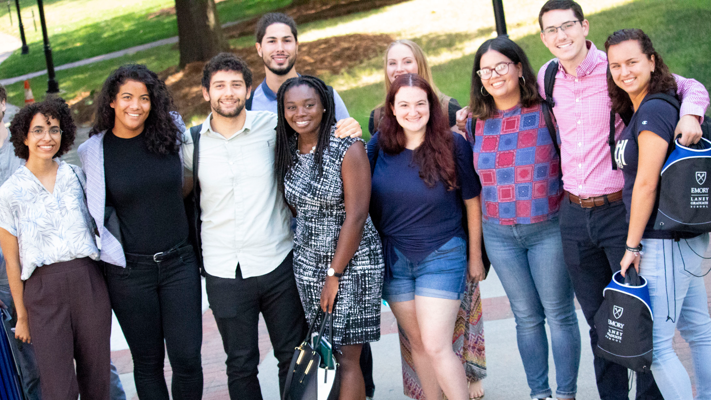 Diverse students stand and smile in a group