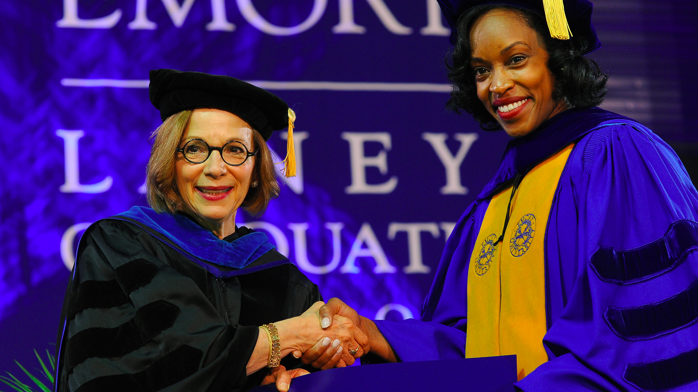 Dean Tedesco shakes hand of graduate.