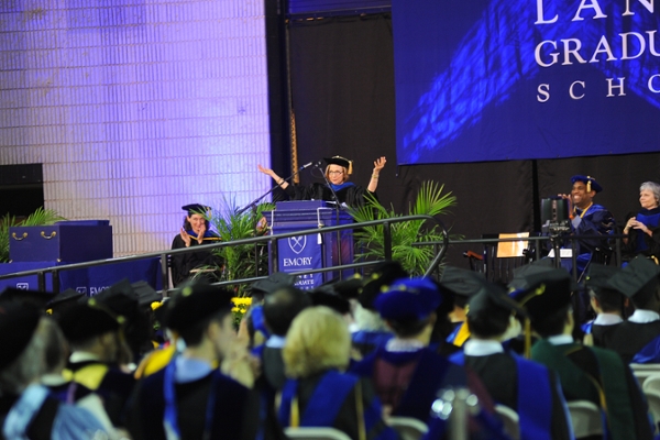 Graduate student received her degree from the dean as the platform guests look on.